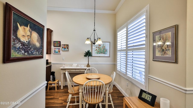 dining space with crown molding, baseboards, wood finished floors, and a chandelier