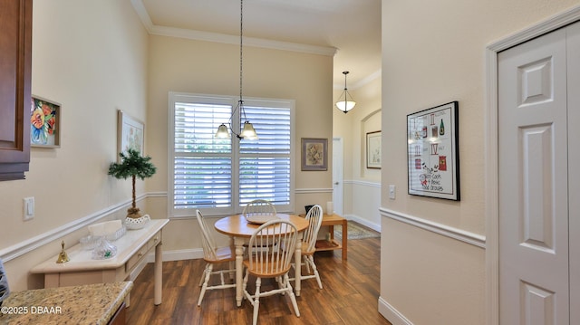 dining room featuring dark wood-style flooring, baseboards, and ornamental molding
