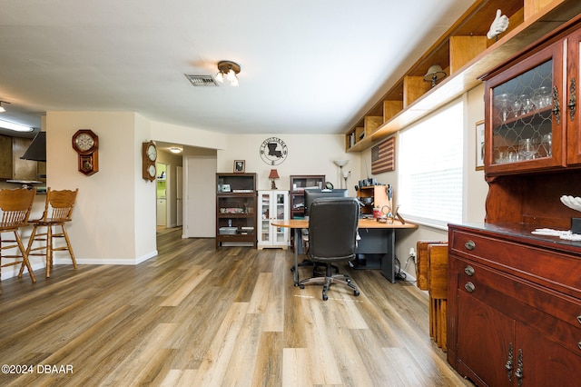 home office featuring baseboards, visible vents, and wood finished floors