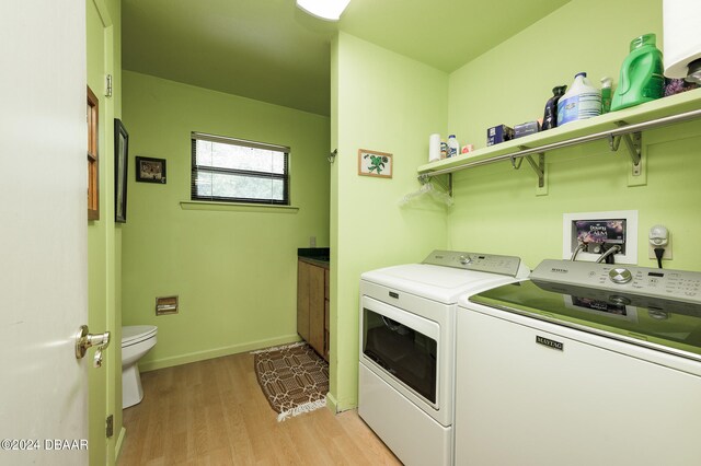 clothes washing area featuring washer and dryer, laundry area, baseboards, and light wood finished floors