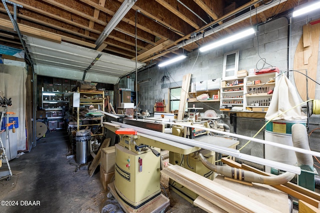 garage with concrete block wall and a workshop area