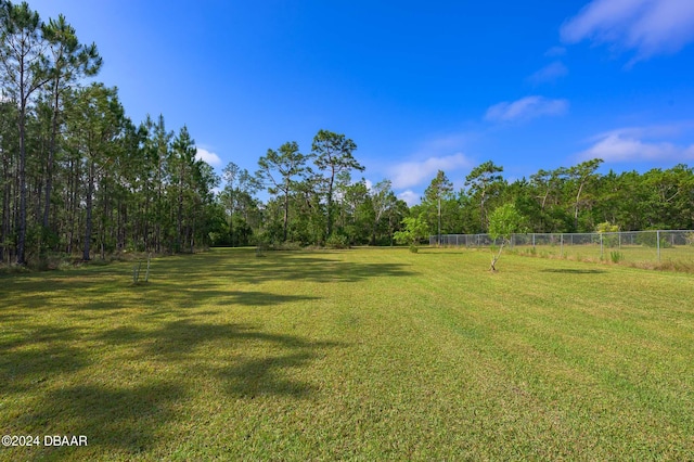 view of yard with fence and a forest view