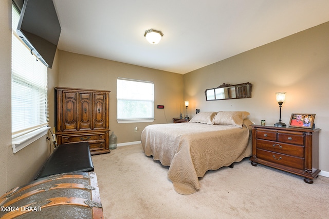 bedroom with light carpet and baseboards