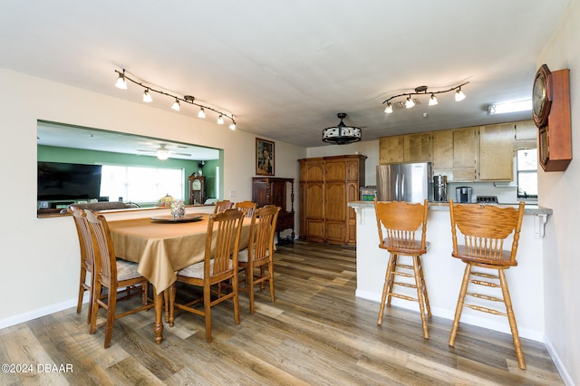 dining space featuring wood finished floors and baseboards