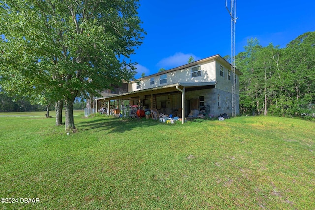 rear view of property featuring a lawn