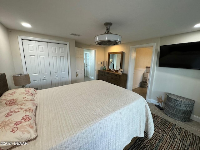 tiled bedroom with ensuite bath and a closet