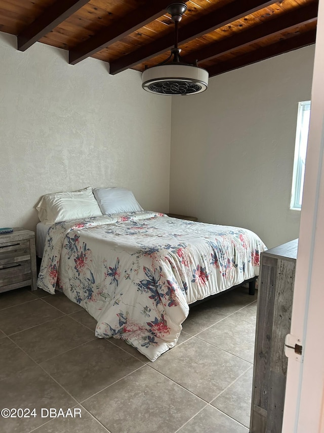 bedroom with tile patterned floors, beam ceiling, and wooden ceiling