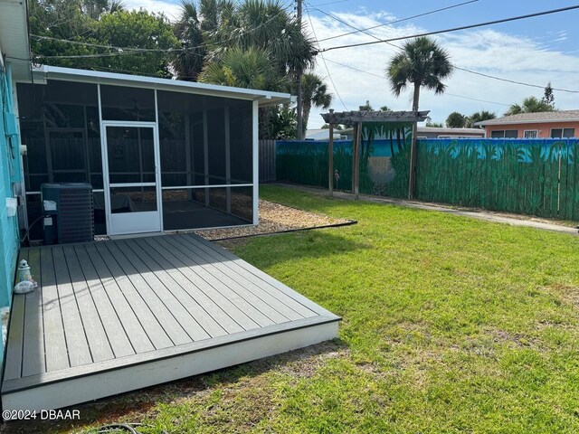 view of yard with central AC unit, a wooden deck, and a sunroom