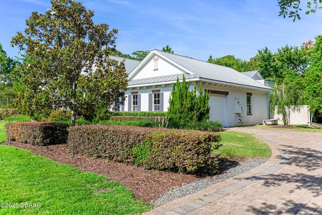 3 Ashford Lakes Dr, Ormond Beach, FL 32174 - view of front of house featuring a garage, driveway, metal roof, and stucco siding