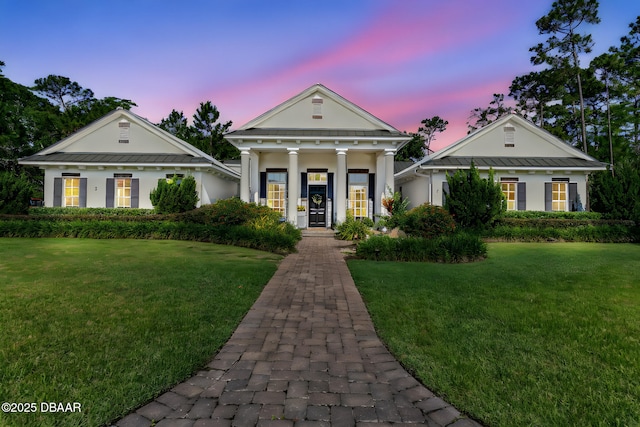 3 Ashford Lakes Dr, Ormond Beach, FL 32174 - greek revival house with a yard, a standing seam roof, metal roof, and stucco siding