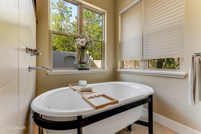 3 Ashford Lakes Dr, Ormond Beach, FL 32174 - bathroom featuring a freestanding tub, baseboards, and tile patterned flooring