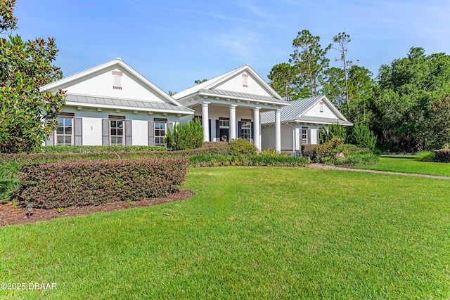 3 Ashford Lakes Dr, Ormond Beach, FL 32174 - greek revival inspired property featuring a standing seam roof, a front yard, metal roof, and stucco siding