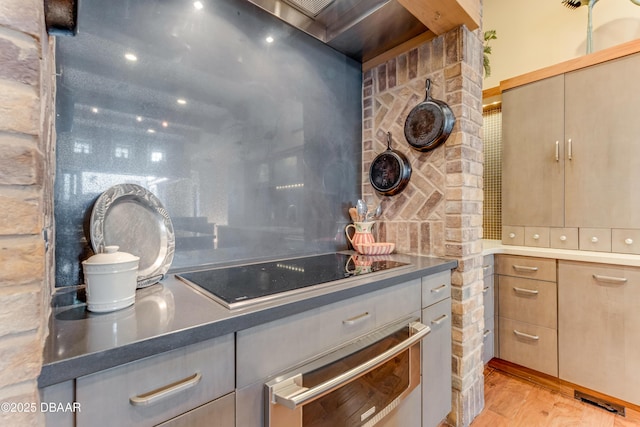3 Ashford Lakes Dr, Ormond Beach, FL 32174 - kitchen with black electric stovetop, backsplash, light wood finished floors, and a warming drawer