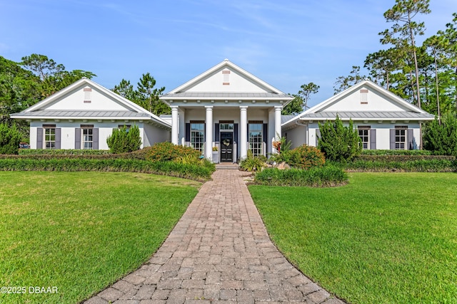 3 Ashford Lakes Dr, Ormond Beach, FL 32174 - greek revival inspired property with a front lawn, stucco siding, metal roof, and covered porch