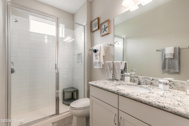 bathroom featuring toilet, vanity, and walk in shower