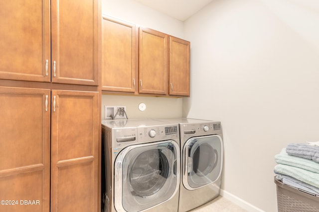 laundry room with cabinets and washing machine and clothes dryer