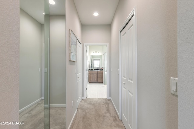 hallway featuring light colored carpet