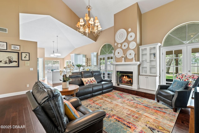 6 Leisure Wood Way, Ormond Beach, FL 32174 - living room featuring an inviting chandelier, dark wood-style flooring, high vaulted ceiling, and a warm lit fireplace