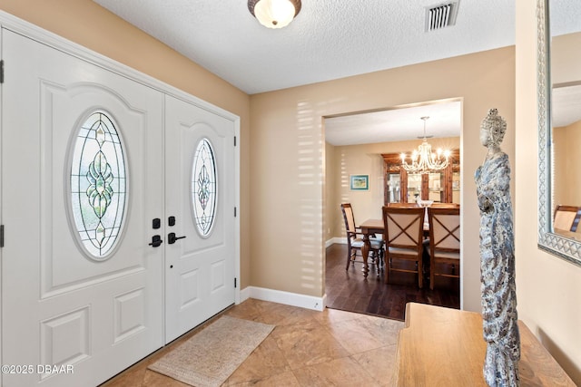 6 Leisure Wood Way, Ormond Beach, FL 32174 - foyer featuring a textured ceiling, visible vents, a notable chandelier, and baseboards
