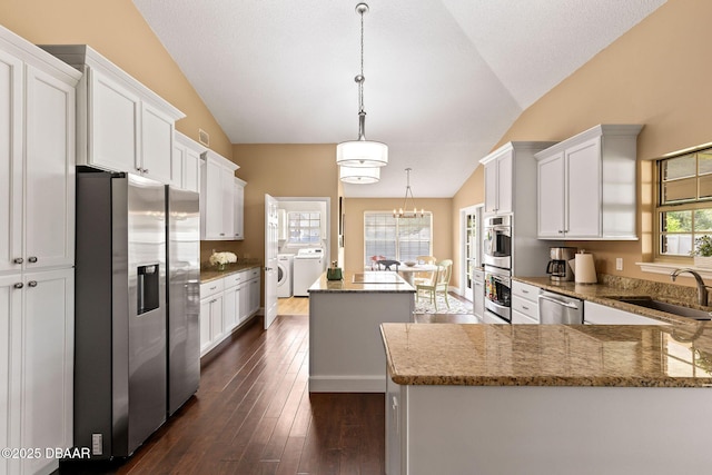 6 Leisure Wood Way, Ormond Beach, FL 32174 - kitchen featuring a sink, washer and clothes dryer, a center island, white cabinetry, and appliances with stainless steel finishes