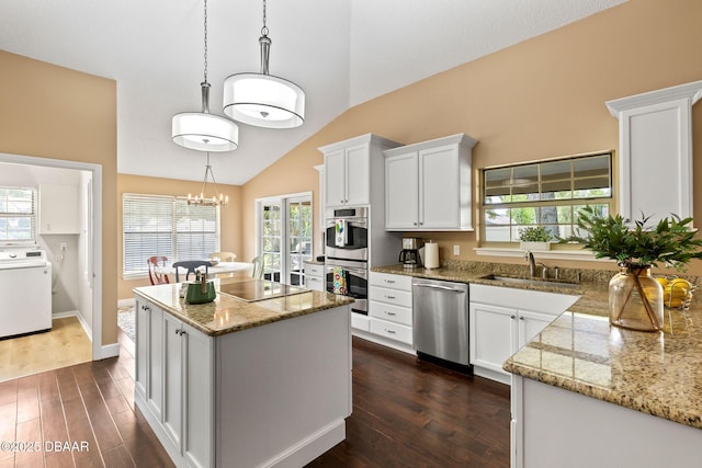 6 Leisure Wood Way, Ormond Beach, FL 32174 - kitchen with stainless steel appliances, washer / dryer, a sink, dark wood-style floors, and a center island