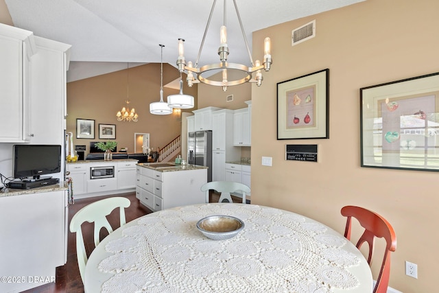 6 Leisure Wood Way, Ormond Beach, FL 32174 - dining area featuring dark wood finished floors, stairway, visible vents, a notable chandelier, and high vaulted ceiling