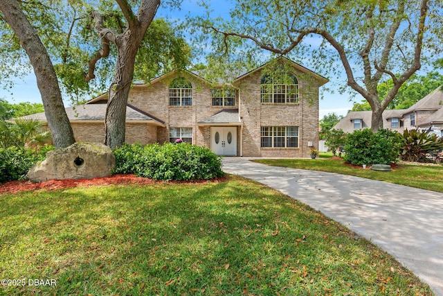 6 Leisure Wood Way, Ormond Beach, FL 32174 - traditional home featuring brick siding, a front yard, and driveway