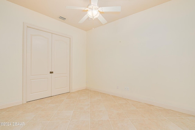 unfurnished room featuring light tile patterned floors, visible vents, baseboards, and a ceiling fan