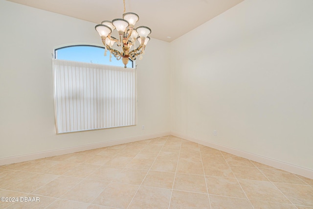 tiled spare room with baseboards and a chandelier