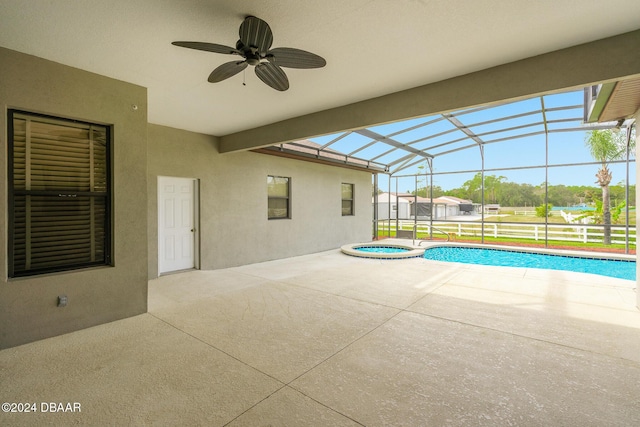 view of swimming pool featuring glass enclosure, a patio, a ceiling fan, and a pool with connected hot tub