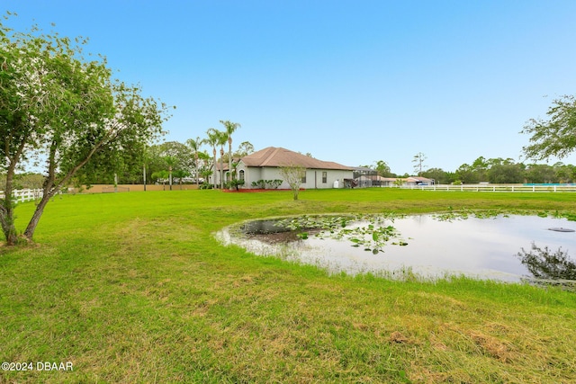 view of yard featuring a water view and fence