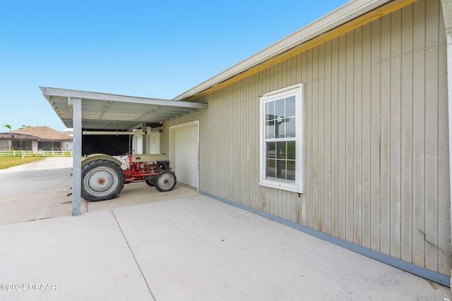 view of property exterior featuring a carport, an attached garage, and driveway