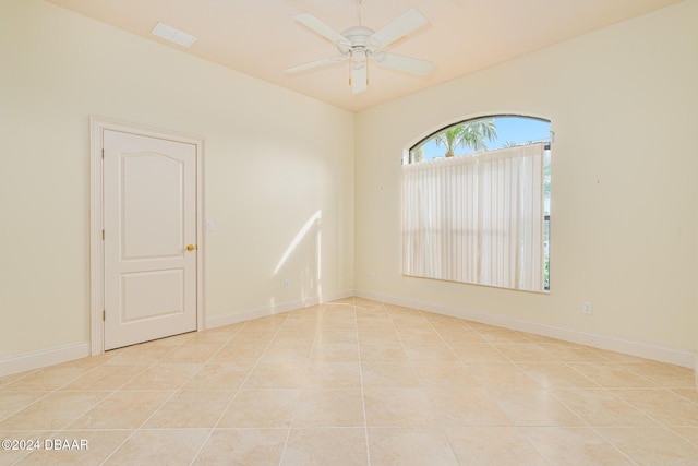 unfurnished room with ceiling fan, baseboards, and light tile patterned flooring