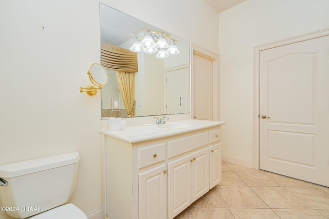 bathroom with toilet, vanity, and tile patterned flooring