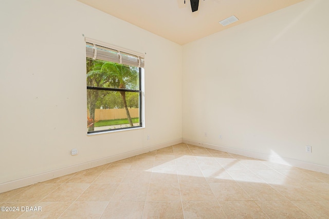 spare room with tile patterned floors, baseboards, visible vents, and ceiling fan