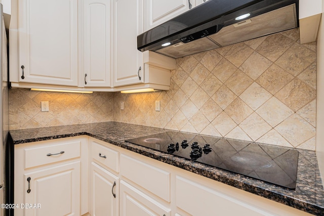 kitchen with under cabinet range hood, backsplash, white cabinets, and black electric stovetop