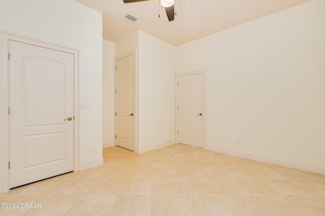 empty room featuring visible vents, baseboards, ceiling fan, and light tile patterned flooring