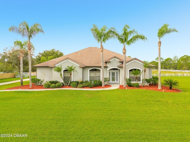 mediterranean / spanish-style house with stucco siding and a front lawn