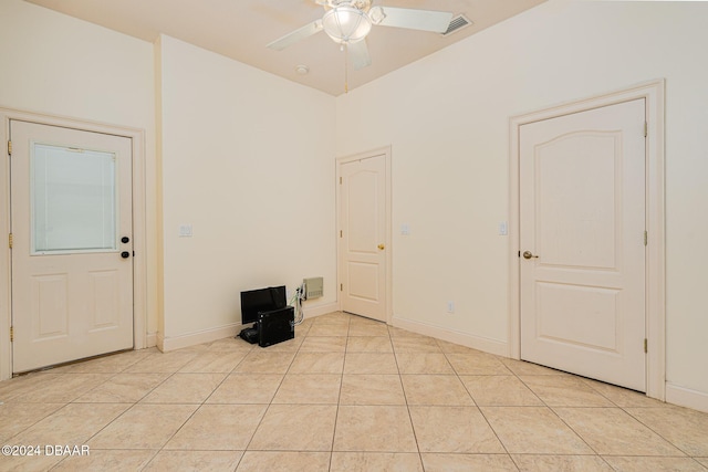 unfurnished room with visible vents, light tile patterned floors, a ceiling fan, and baseboards