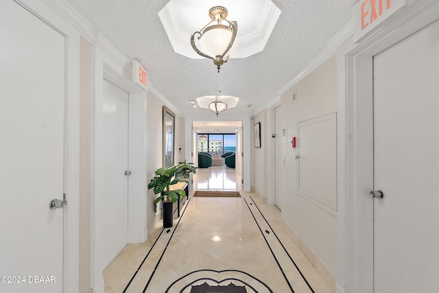 hall featuring crown molding and a textured ceiling