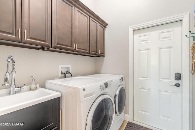 clothes washing area with cabinets, separate washer and dryer, and sink