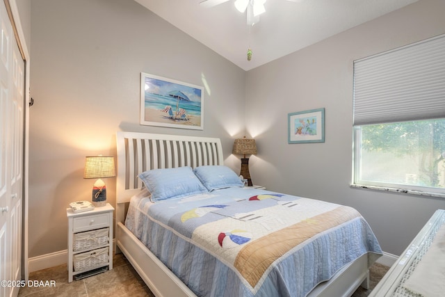 tiled bedroom with ceiling fan, lofted ceiling, and a closet