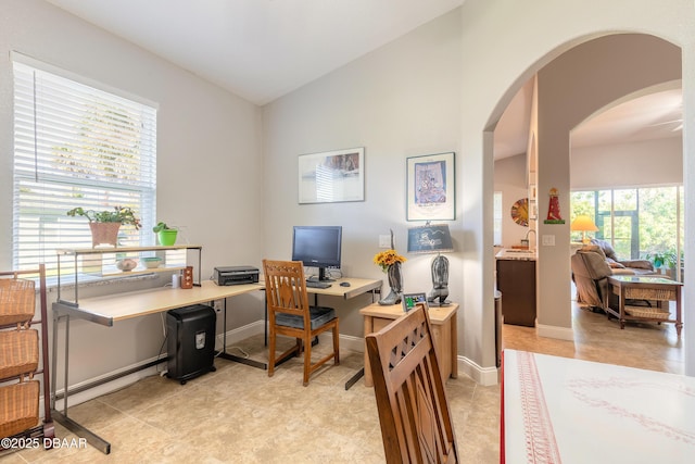 home office with light tile patterned floors and vaulted ceiling