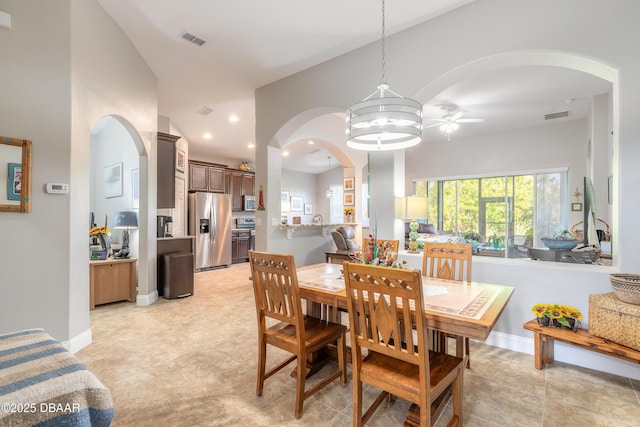 dining space with ceiling fan with notable chandelier