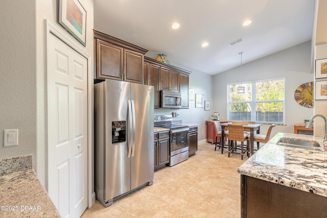 kitchen featuring appliances with stainless steel finishes, dark brown cabinets, sink, pendant lighting, and lofted ceiling