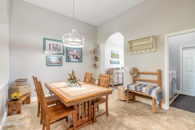 dining space with washing machine and dryer and a chandelier