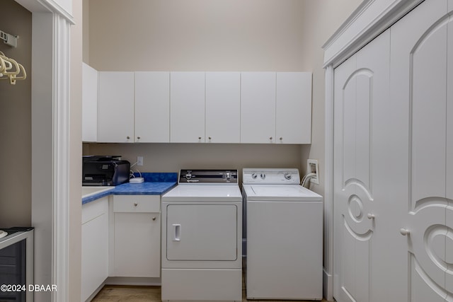 washroom with cabinets, light wood-type flooring, and independent washer and dryer