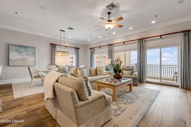 living room featuring ornamental molding, wood-type flooring, a healthy amount of sunlight, and ceiling fan