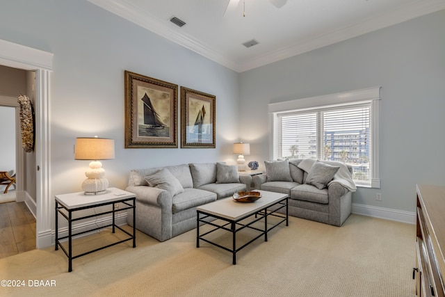 living room featuring ornamental molding, light hardwood / wood-style flooring, and ceiling fan