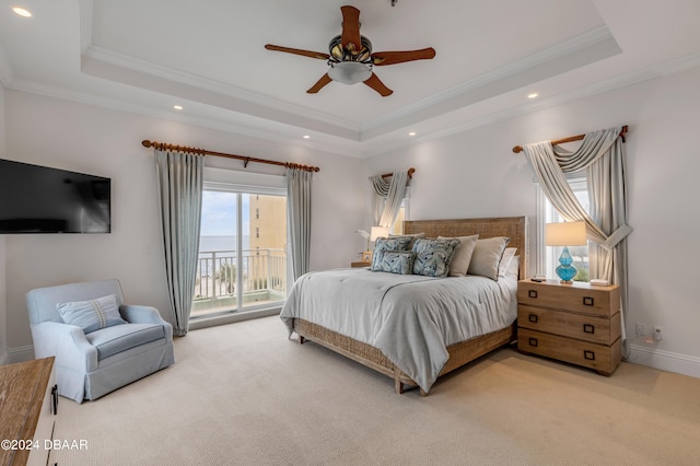 carpeted bedroom with ceiling fan, a tray ceiling, crown molding, and access to outside